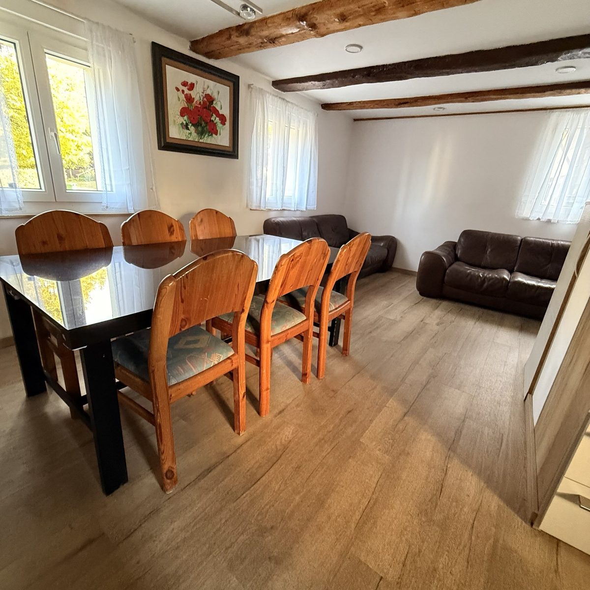 Cozy Swiss Hub – open living and dining room with wooden beams
